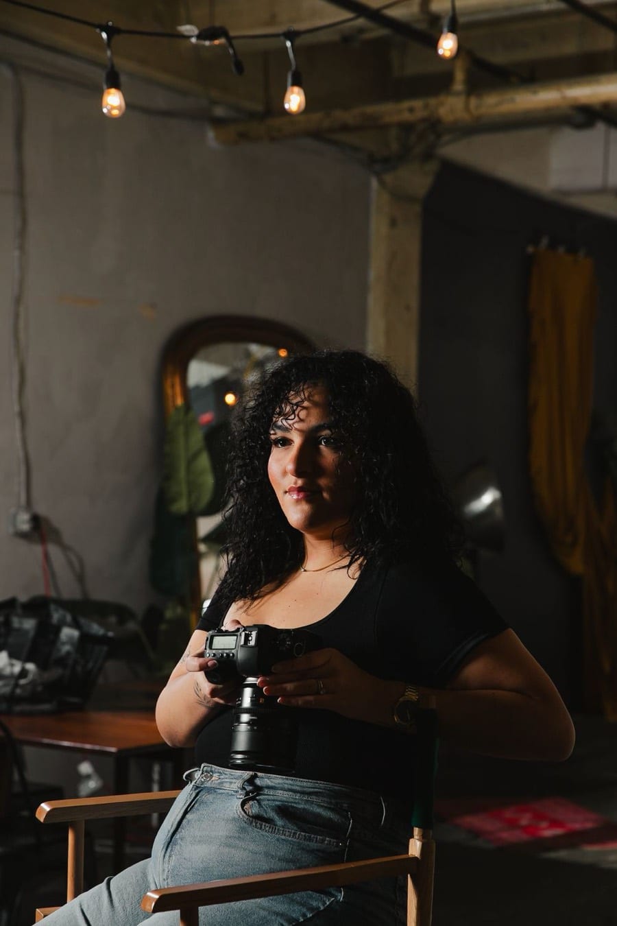 Amy of Create With Amy, Baltimore photographer and creative director, seated in a director's chair with her camera