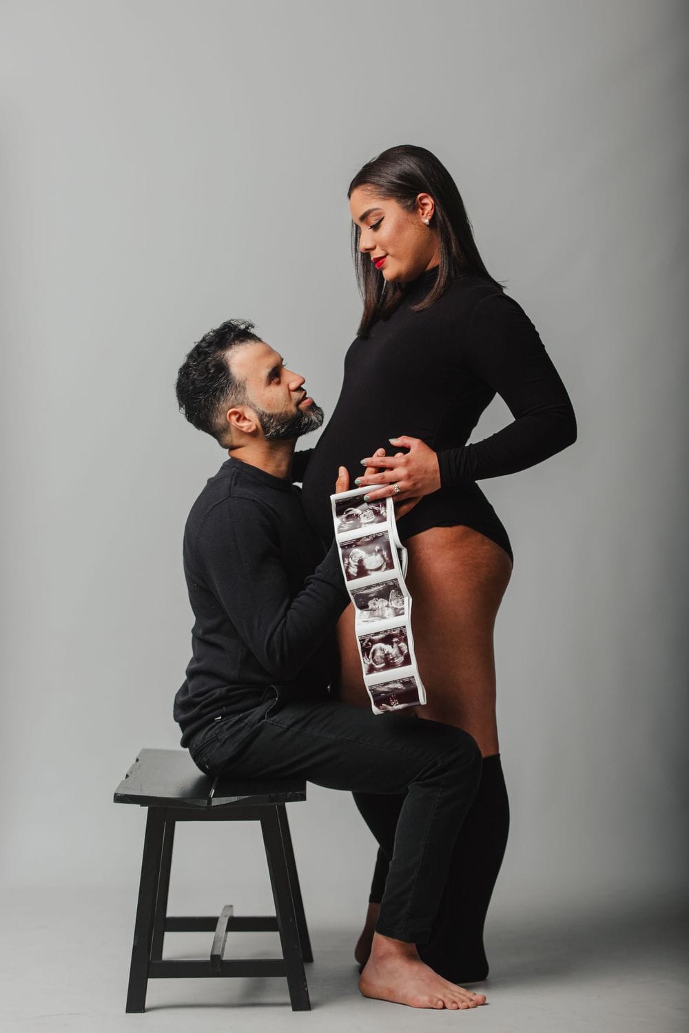 Maternity photo session on a gray backdrop with ultrasound prints, by Create With Amy, maternity photographer serving Harford County and Baltimore